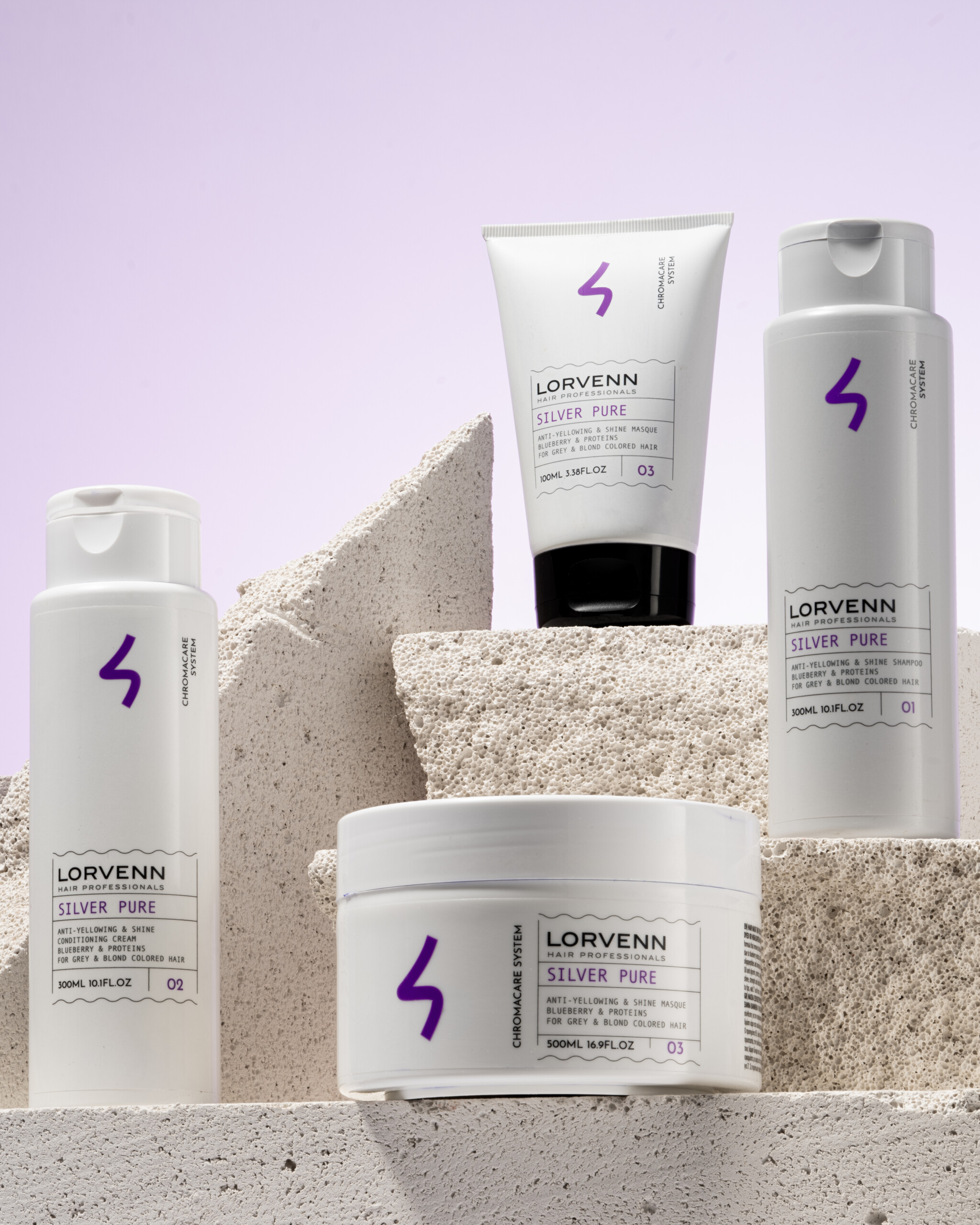 Lorvenn Silver Pure hair care products arranged on textured stone blocks against a pale purple background.