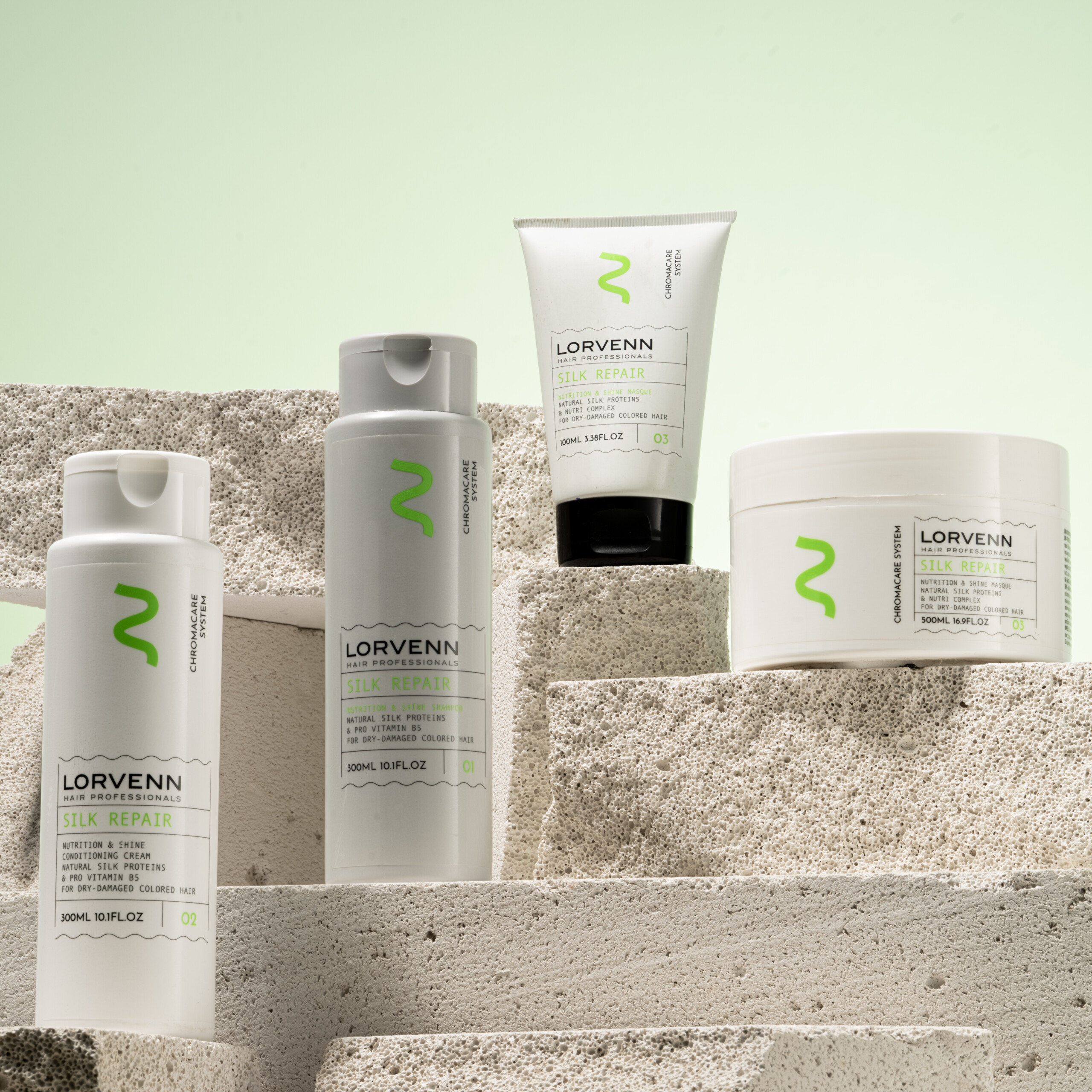 Lorvenn Silk Repair hair care products arranged on textured stone blocks against a pale green background.